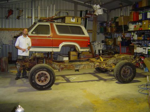 1984 Ford Bronco - A Ford Bronco body sits atop its chassis in a workshop, undergoing restoration.
