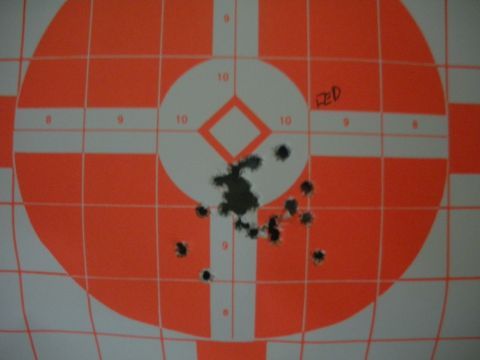 1996 Ford Bronco - A target displays a cluster of bullet impacts around the center, with the word 'RED' scrawled in the upper right quadrant.