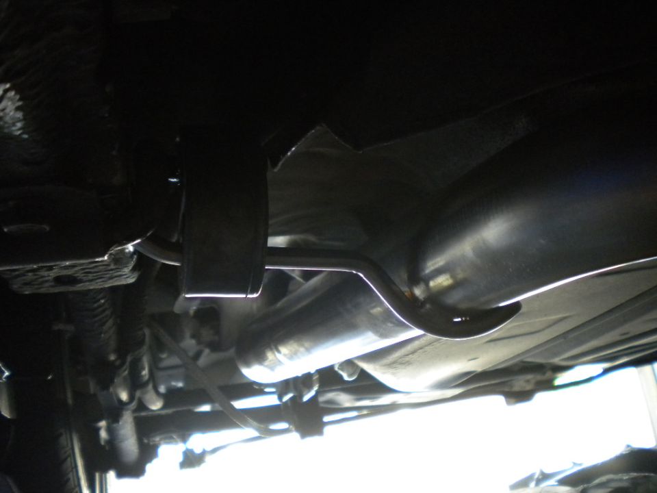 Underbody view of exhaust pipe, muffler and fuel tank straps