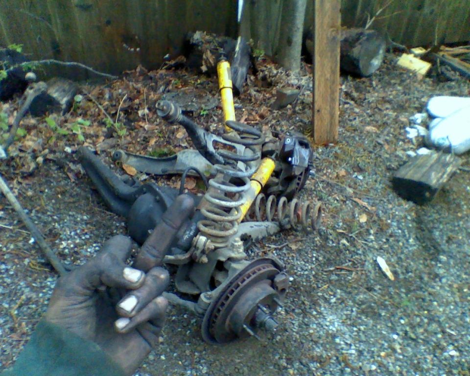 Suspension parts including springs and brake components scattered on the ground