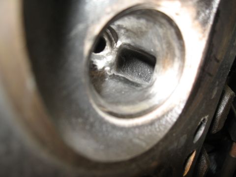 1994 Ford Bronco - A detailed view of a mechanical component, likely part of an engine, showing a square recess.