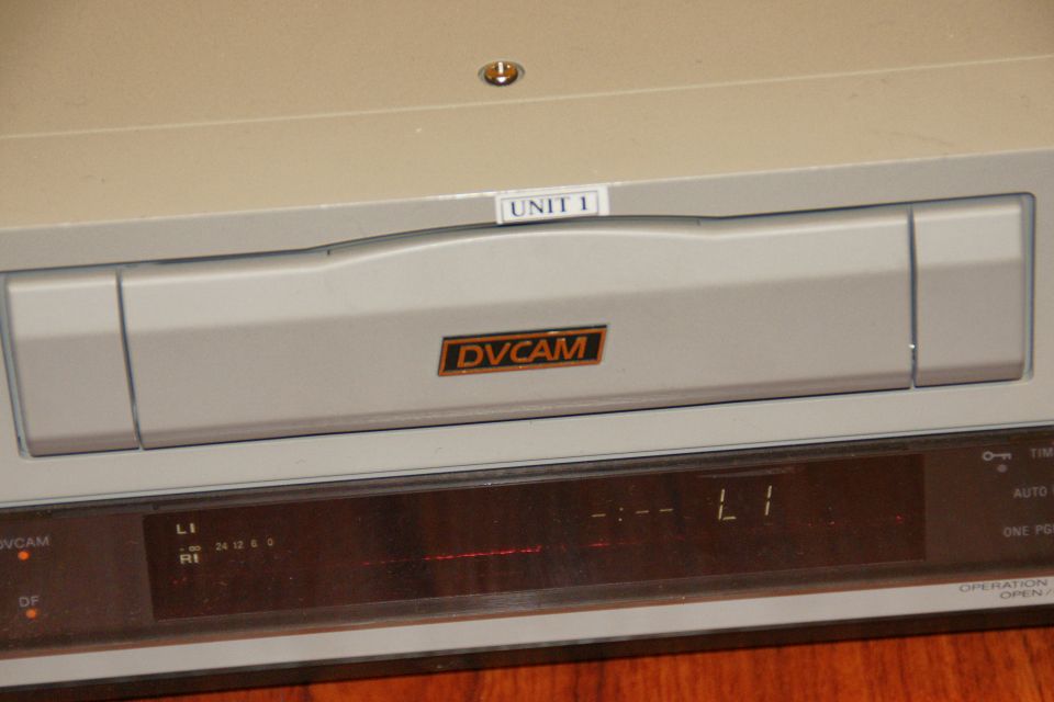 Close-up of a DVCAM video recorder with 'UNIT 1' label and digital display