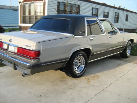 1988 Mercury Grand Marquis - This 1988 Mercury Grand Marquis is seen from a three-quarter front angle, showing its tan exterior and black vinyl roof.