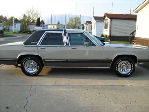 1988 Mercury Grand Marquis - Side view of a 1988 Mercury Grand Marquis sedan parked on a concrete driveway.