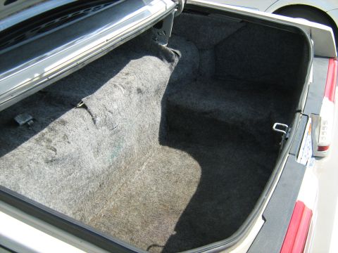 1988 Mercury Grand Marquis - The interior of a car's trunk is shown, gray carpeting and a visible latch mechanism.