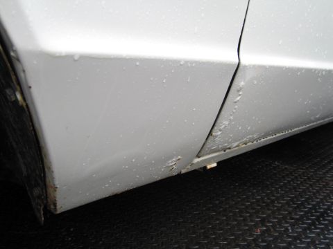 1991 Ford LTD Crown Victoria - Close-up of a car's lower door panel showing rust and water damage.