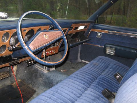 1991 Ford LTD Crown Victoria - The interior of an older vehicle features blue velour seats and dashboard accents.