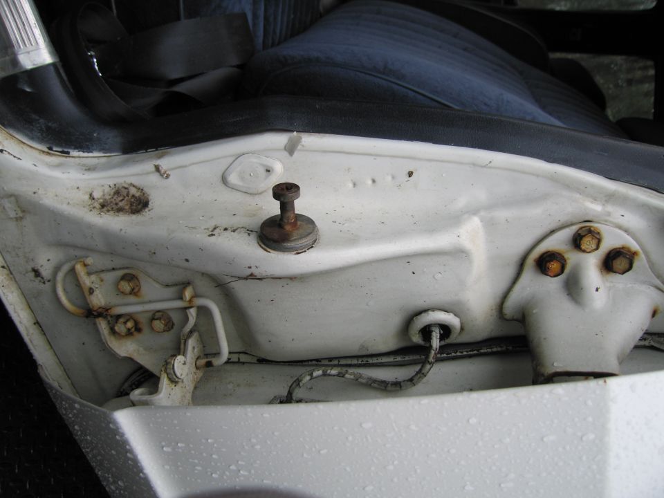 Close-up of a car's door jamb area, showing the latch mechanism and some wiring