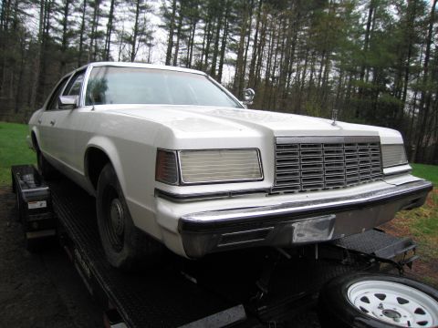 1991 Ford LTD Crown Victoria - A white 1983 Ford sedan is loaded onto a trailer, viewed from the front-right.