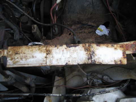 1991 Ford LTD Crown Victoria - Close-up of a corroded metal plate and wiring in an engine compartment.