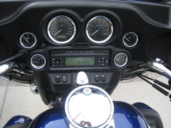 Harley-Davidson fairing gauge cluster and radio above a blue fuel tank with chrome console