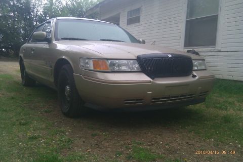2000 Mercury Grand Marquis - Front view of a tan 2000 Mercury Grand Marquis parked on grass.