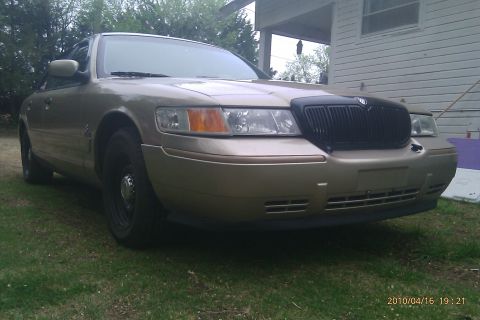 2000 Mercury Grand Marquis - Front 3/4 view of a gold 2000 Mercury Grand Marquis with a black grille.