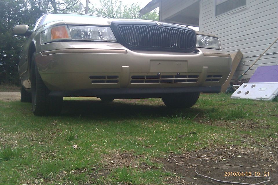 Front view of a gold 2000 Mercury Grand Marquis with a black grille
