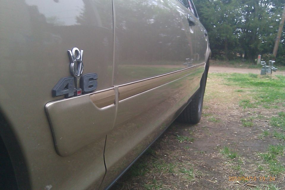 car fender with 4.6 V8 emblem and woodgrain trim