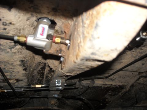 1979 Ford F-150 - Close-up view of brake lines and a component on the underbody of a vehicle.