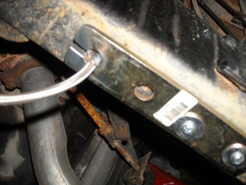 1979 Ford F-150 - Close-up view of vehicle undercarriage components, including a brake line and a barcode sticker.