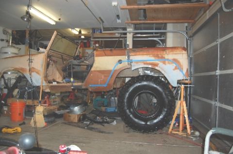 1961 International Scout 800 - A vehicle body in a state of disrepair, possibly undergoing restoration, is parked inside a garage.