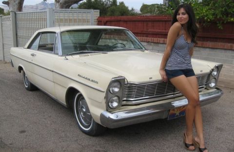 1991 Ford Crown Victoria - A woman poses with a classic 1965 Ford Galaxie 500, not a 1991 Ford Crown Victoria.