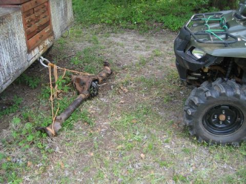 1995 Ford Bronco - A detached rear axle assembly is tied to a trailer, with an ATV parked to its right.