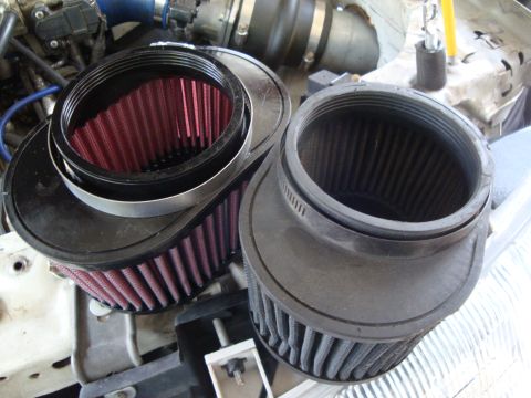 1995 Ford Taurus - Comparison of two engine air filters, one with red filter media and the other with black.
