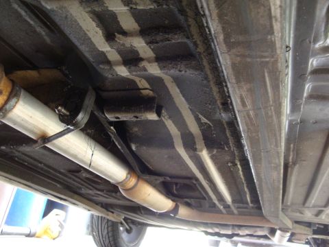 1995 Ford Taurus - The undercarriage of a vehicle, revealing the exhaust system and structural components.
