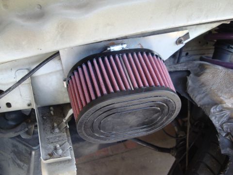 1995 Ford Taurus - Close-up of an aftermarket engine air filter installed in a vehicle's engine bay.