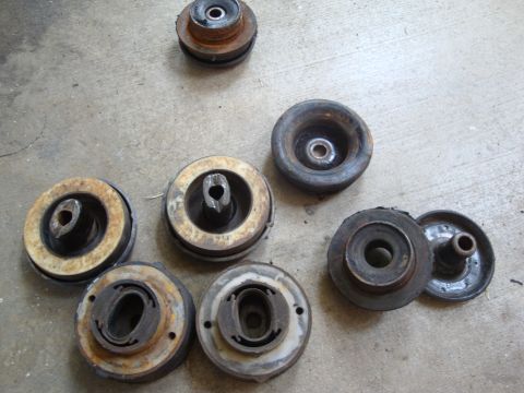 1995 Ford Taurus - A collection of various worn suspension components are laid out on a concrete floor.