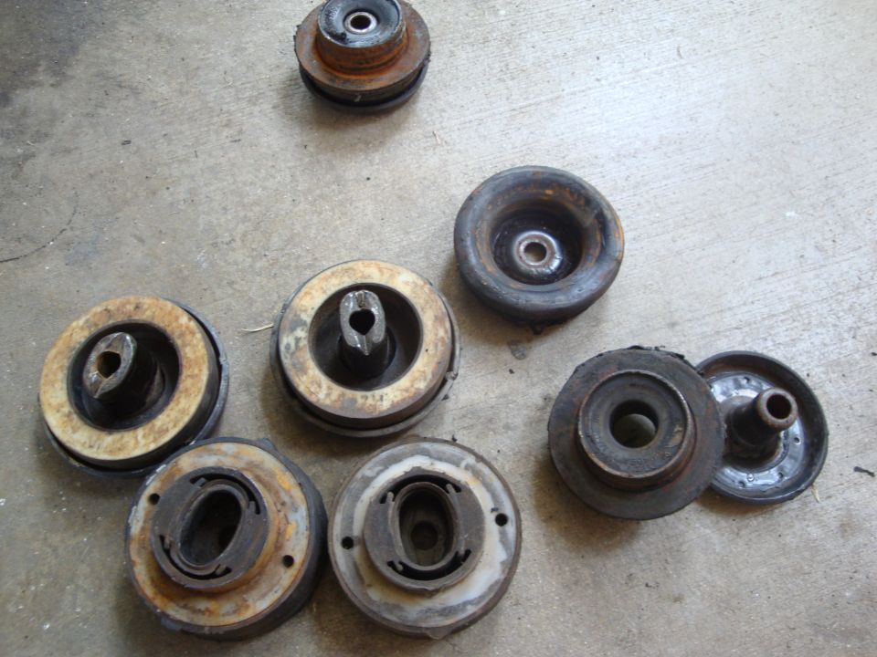 Several used suspension parts on a concrete surface