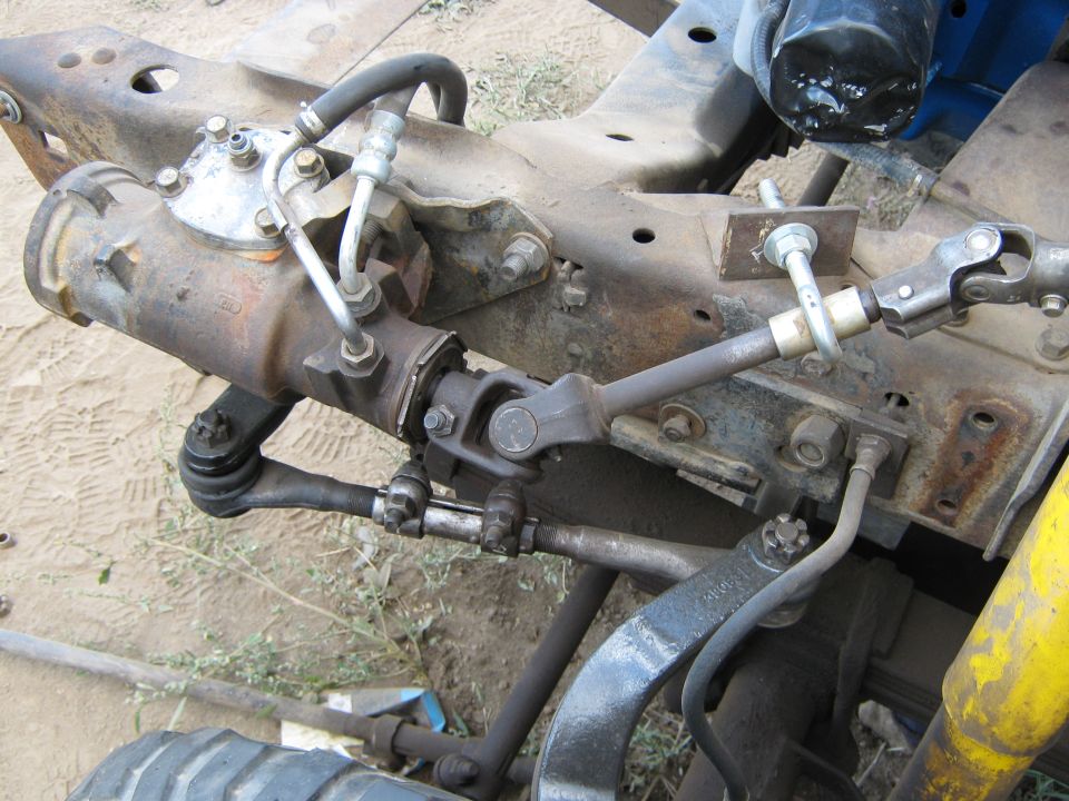 close-up of truck steering box, tie rods, and suspension parts