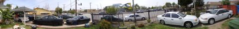 1995 Ford Taurus - A white 1995 Ford Taurus sedan is parked on the grass next to a fence.
