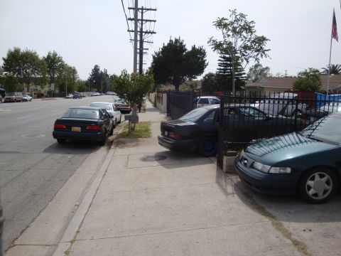 1995 Ford Taurus - Several cars are parked along a residential street, including a 1995 Ford Taurus.