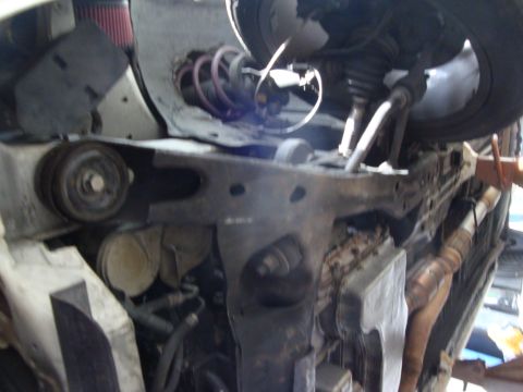 1995 Ford Taurus - Close-up of a car's engine bay and suspension system, with visible pulleys and exhaust parts.