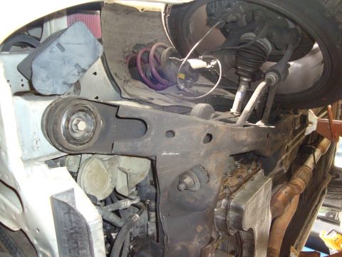 1995 Ford Taurus - Close-up view of the underside of a vehicle, focusing on the suspension system and engine components.