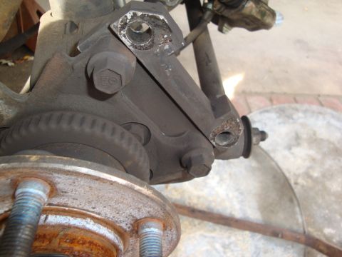 1995 Ford Taurus - A detailed view of a vehicle's suspension components, focusing on the brake caliper bracket and hub assembly.