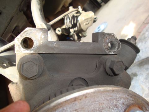 1995 Ford Taurus - Close-up view of a vehicle's brake caliper bracket, showing mounting bolts and surrounding components.