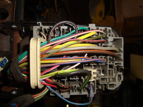1995 Ford Taurus - A complex network of wires connects to a vehicle's fuse box, suggesting electrical system components.