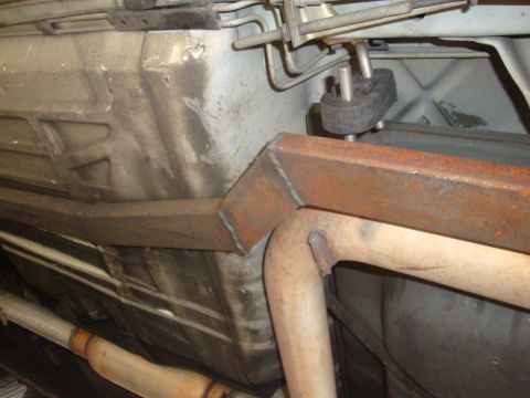 1995 Ford Taurus - Close-up view of the underside of a vehicle, showing custom metalwork on the exhaust and fuel tank.