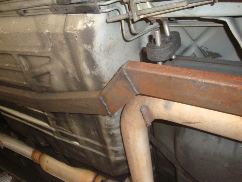 Vehicle underbody with rusty metal reinforcements welded to the exhaust system and fuel tank