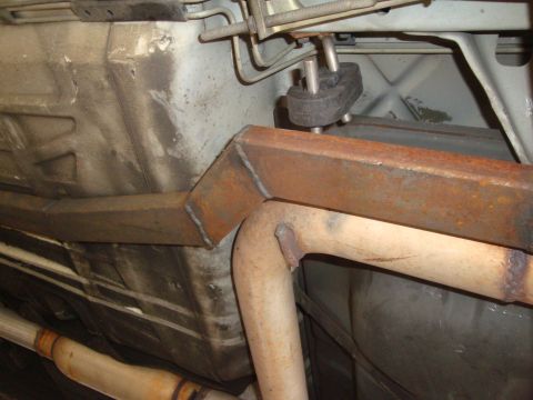 1995 Ford Taurus - Close-up view of the undercarriage, showing exhaust pipes and a custom-welded metal brace.