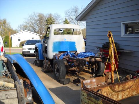 1954 Ford F-100 - A truck is being worked on, with its body lifted off the chassis and parts scattered around.