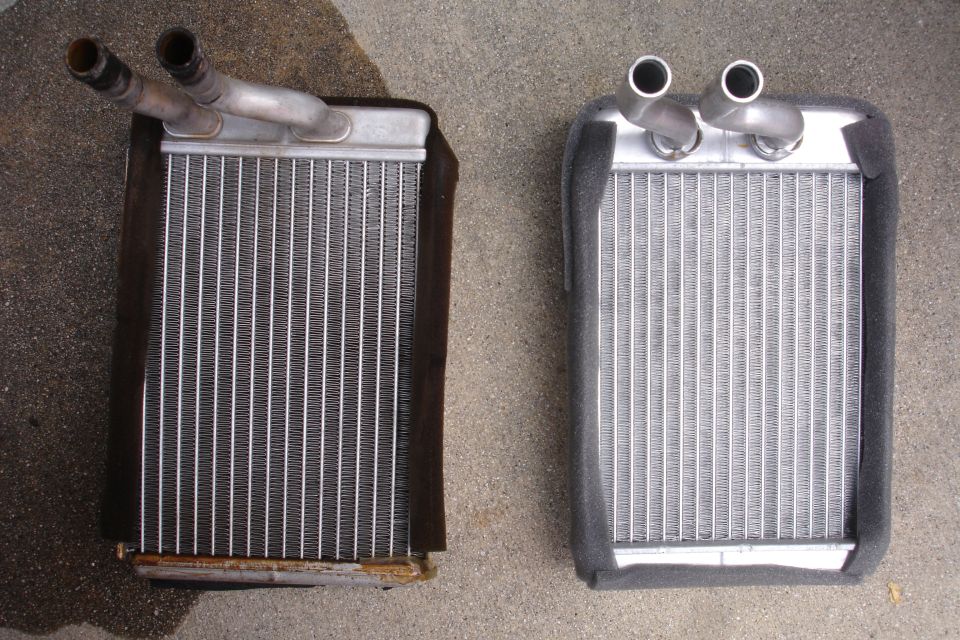 Two heater cores side-by-side, one old and one new, on a concrete surface