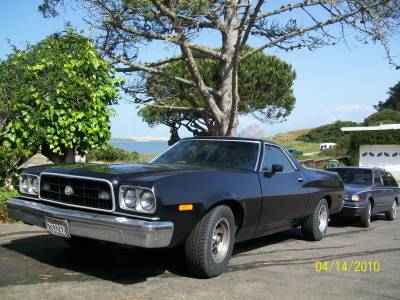 1973 Ford Ranchero - A black 1973 Ford Ranchero pickup truck is seen parked on a street with another vehicle behind it.