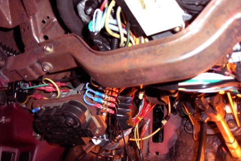 1992 Ford Crown Victoria - Under-dash view of wiring work in progress, with the dash removed to expose the rusty steel cowl support bar and factory harnesses. A brass…