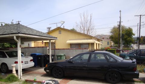 1995 Ford Taurus - A black 1995 Ford Taurus is parked in the driveway next to a white car.