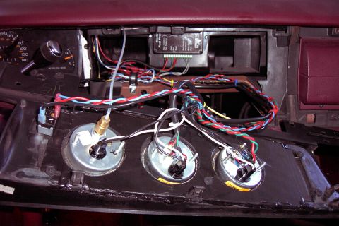 1992 Ford Crown Victoria - In-progress wiring of three aftermarket gauges mounted in a custom dash panel, viewed from behind with the trim removed. Twisted red, green…