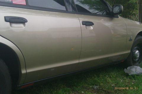 2000 Mercury Grand Marquis - Tan 2000 Mercury Grand Marquis side profile, showing door handles and fender detail.