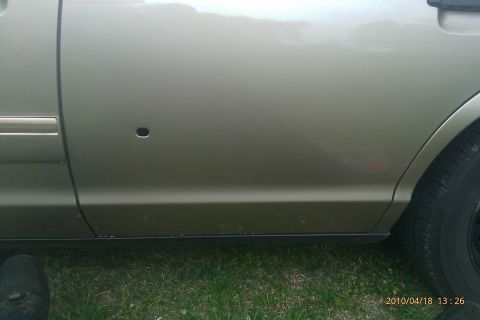 2000 Mercury Grand Marquis - Passenger side rear door of a 2000 Mercury Grand Marquis shows damage.