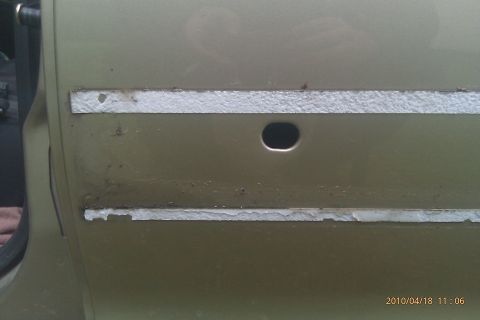 2000 Mercury Grand Marquis - Close-up of a car door showing missing trim and a hole, with a watermark at the bottom right.