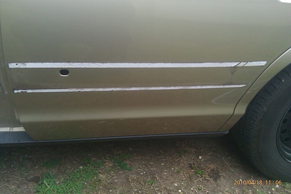 Gold car side panel with two horizontal trim strips, one with a small hole